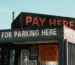 Structure with signs indicating payment for parking, emphasizing the need to pay for parking services.