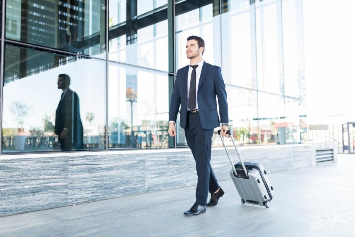 Businessman walking with a suitcase at airport.